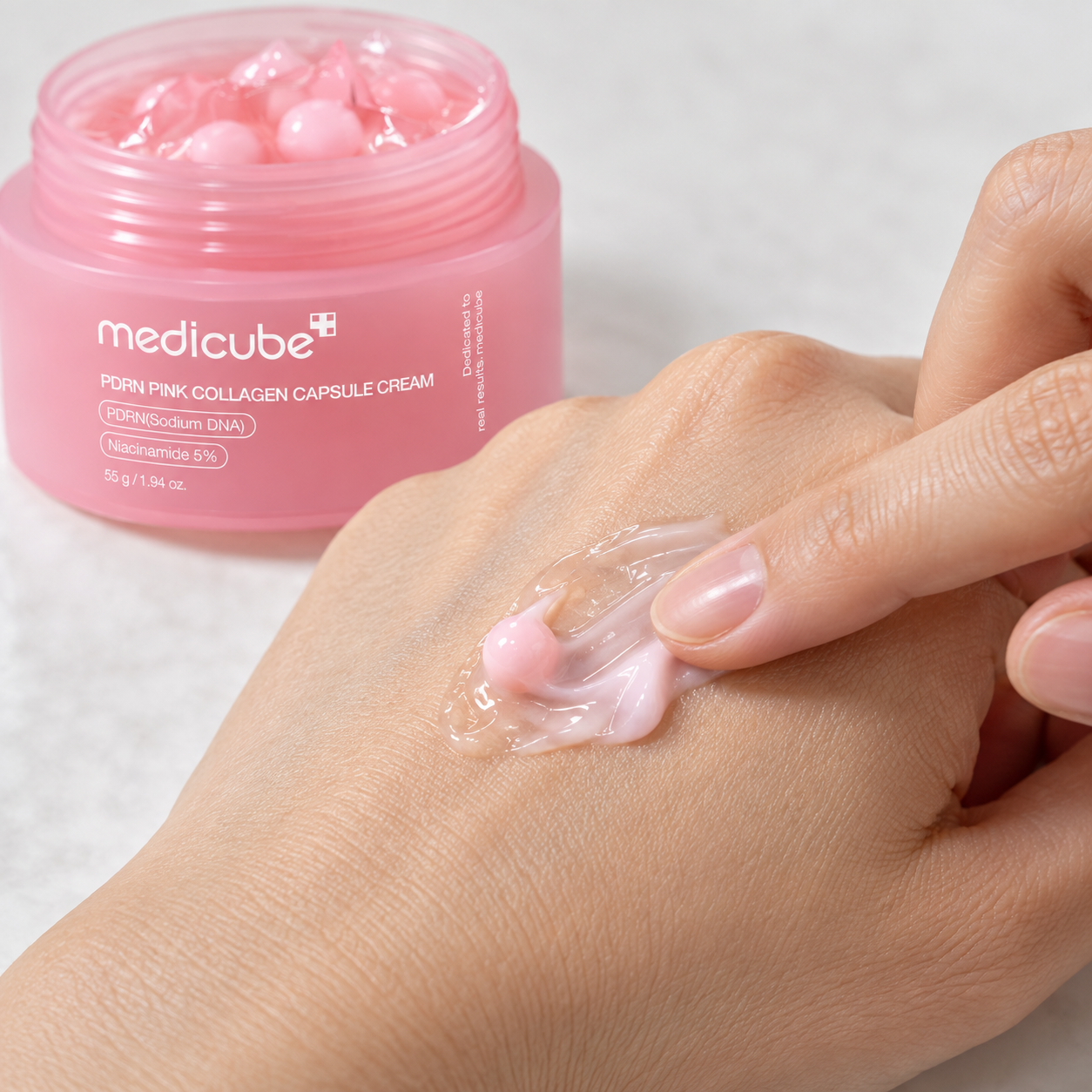 Mezcla de una cápsula rosa con gel de PDRN Pink Collagen Capsule Cream sobre el dorso de una mano