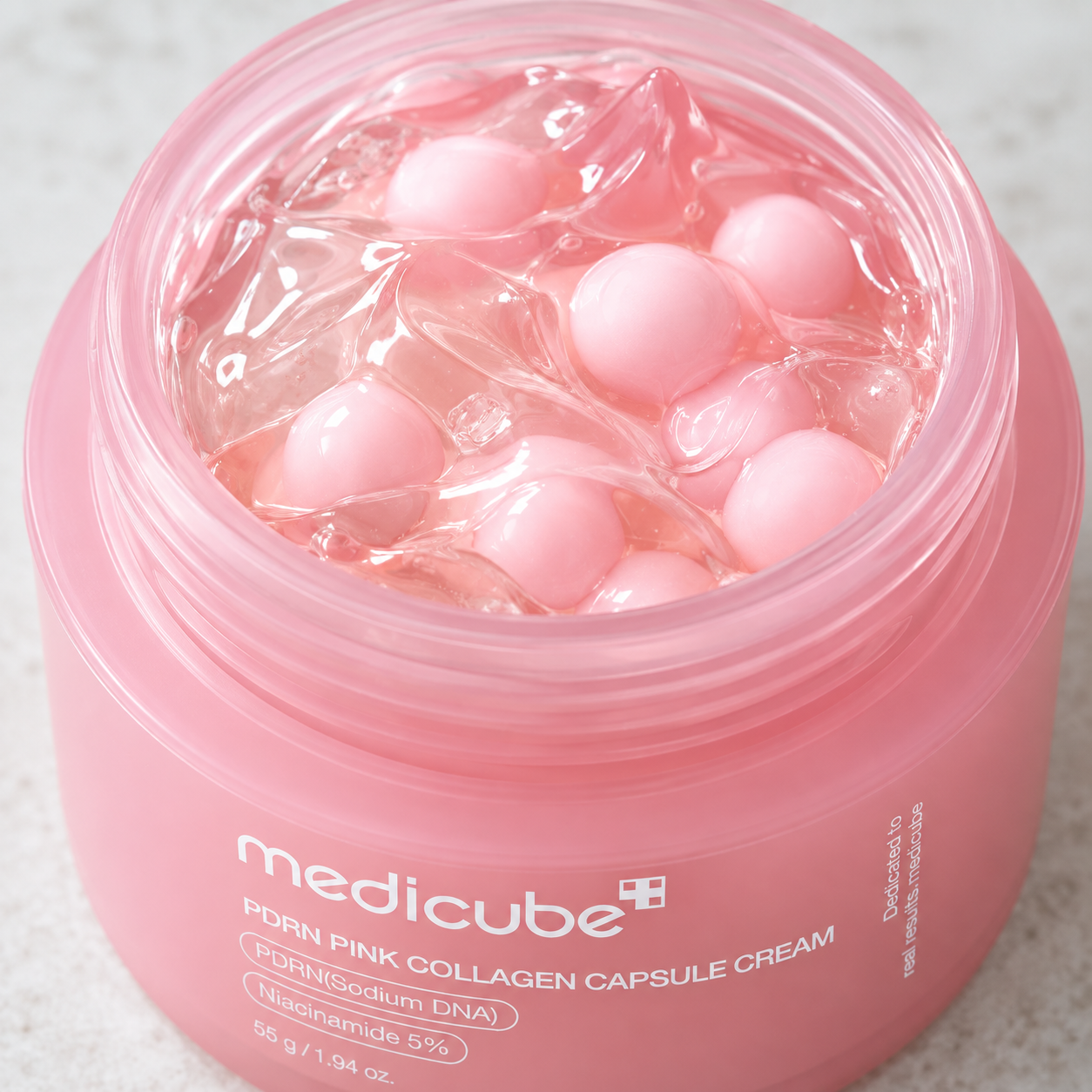 Detalle de las cápsulas rosas y la base transparente de la crema PDRN Pink Collagen