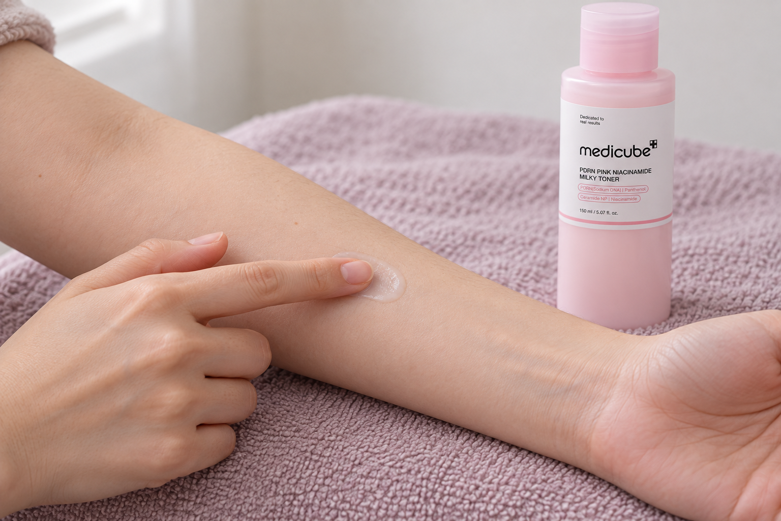 Gesto ilustrativo de aplicar una pequeña cantidad de cosmético en el antebrazo junto al Milky Toner.